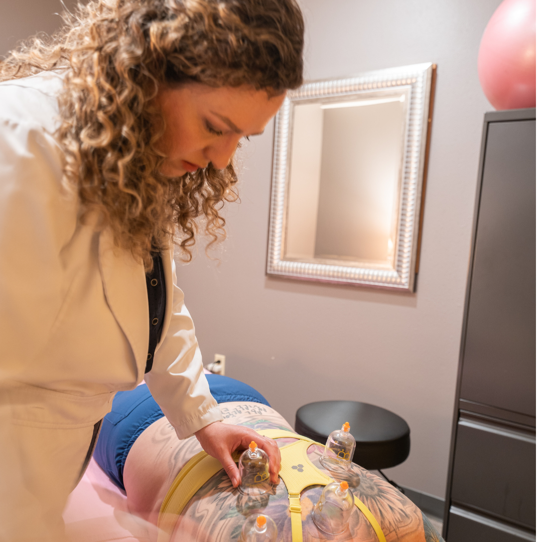 Wider view of the Therapy Unlimited treatment room with a cupping session in progress